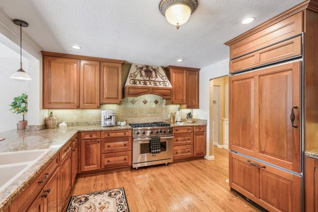 a kitchen with stainless steel appliances granite countertop a stove and a refrigerator