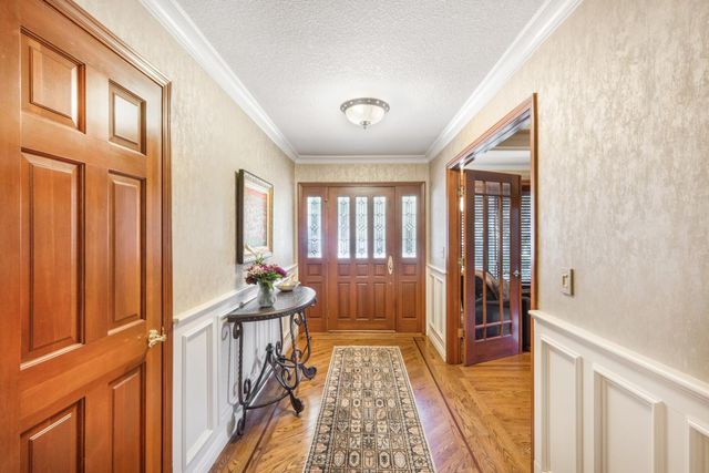 a view of a hallway with furniture and floor to ceiling window