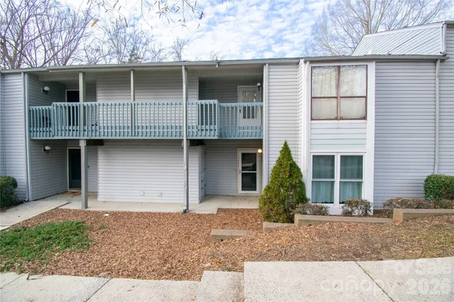 a view of a house with large windows and garage