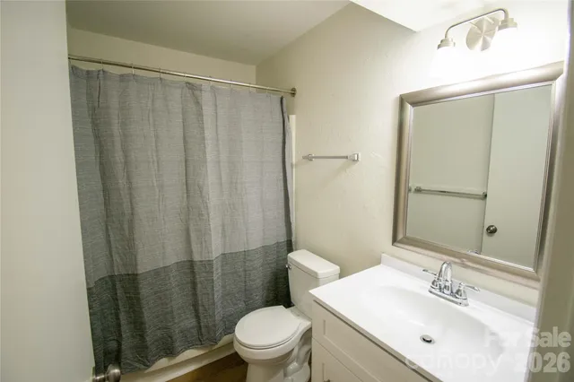 a bathroom with a sink a toilet a mirror and shower