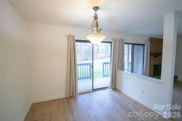 a view of a room with wooden floor water heater and a window