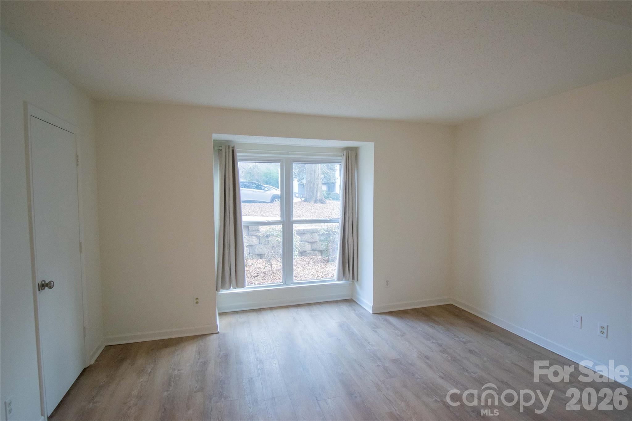 11042 Harrowfield Road Charlotte, NC 28226 - Photo 9 of 14 an empty room with wooden floor and windows
