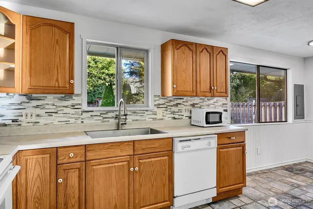 a kitchen with stainless steel appliances granite countertop wooden cabinets a sink and a granite counter tops