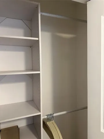 a view of walk in closet with empty racks