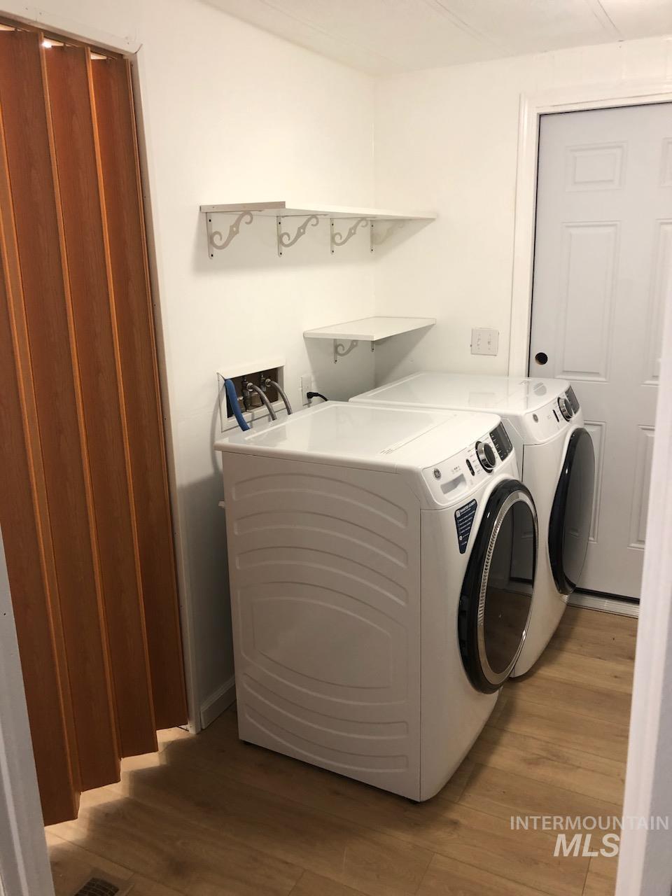 655 Dolson Lane Eagle, ID 83616 - Photo 12 of 23 Laundry room with light wood finished floors and washing machine and dryer