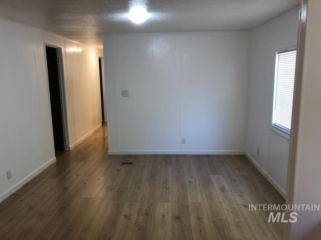 655 Dolson Lane Eagle, ID 83616 - Photo 13 of 23 Unfurnished room featuring dark wood-style flooring and a textured ceiling