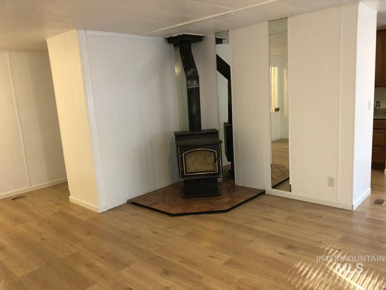 655 Dolson Lane Eagle, ID 83616 - Photo 5 of 23 Unfurnished living room featuring a wood stove and light wood finished floors