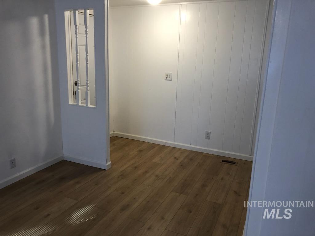 655 Dolson Lane Eagle, ID 83616 - Photo 6 of 23 Empty room with dark wood finished floors and wood walls