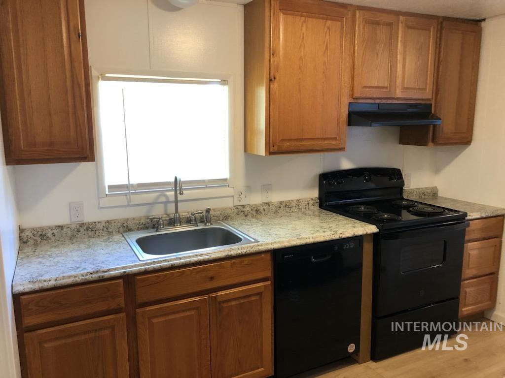 655 Dolson Lane Eagle, ID 83616 - Photo 8 of 23 Kitchen featuring black appliances, wood finish cabinetry, light countertops, and light wood-type flooring