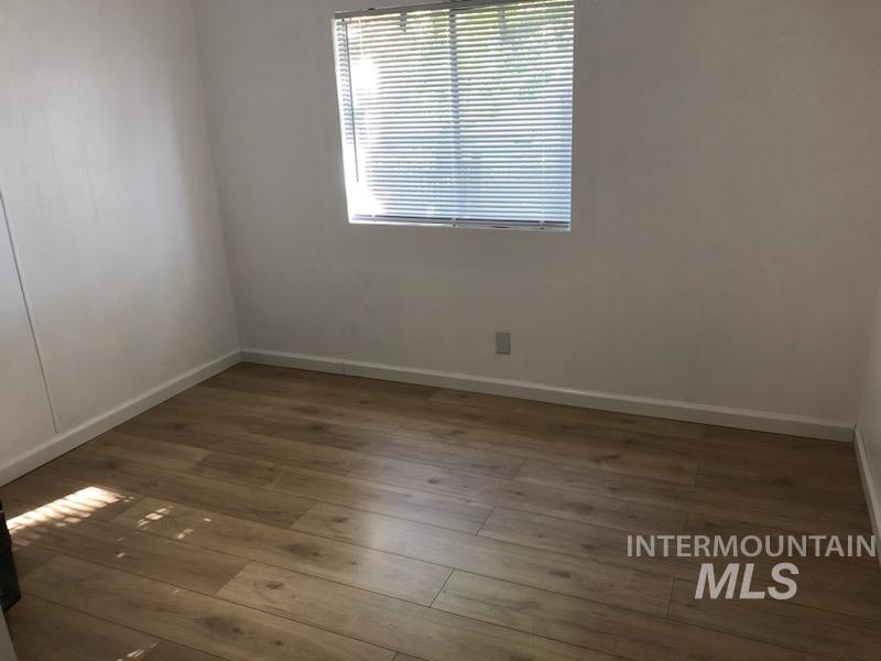 655 Dolson Lane Eagle, ID 83616 - Photo 10 of 23 Unfurnished room featuring baseboards and hardwood / wood-style flooring