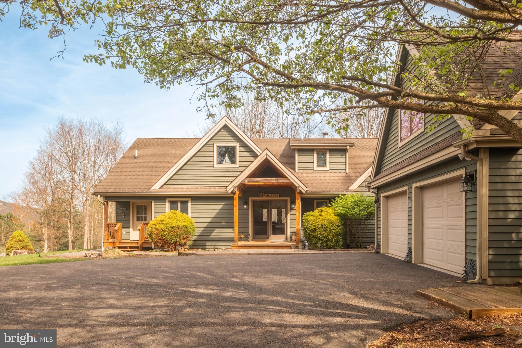 128 Bridgeview Lane Swanton, MD 21561 - Photo 38 of 70 a front view of a house with a garden and trees