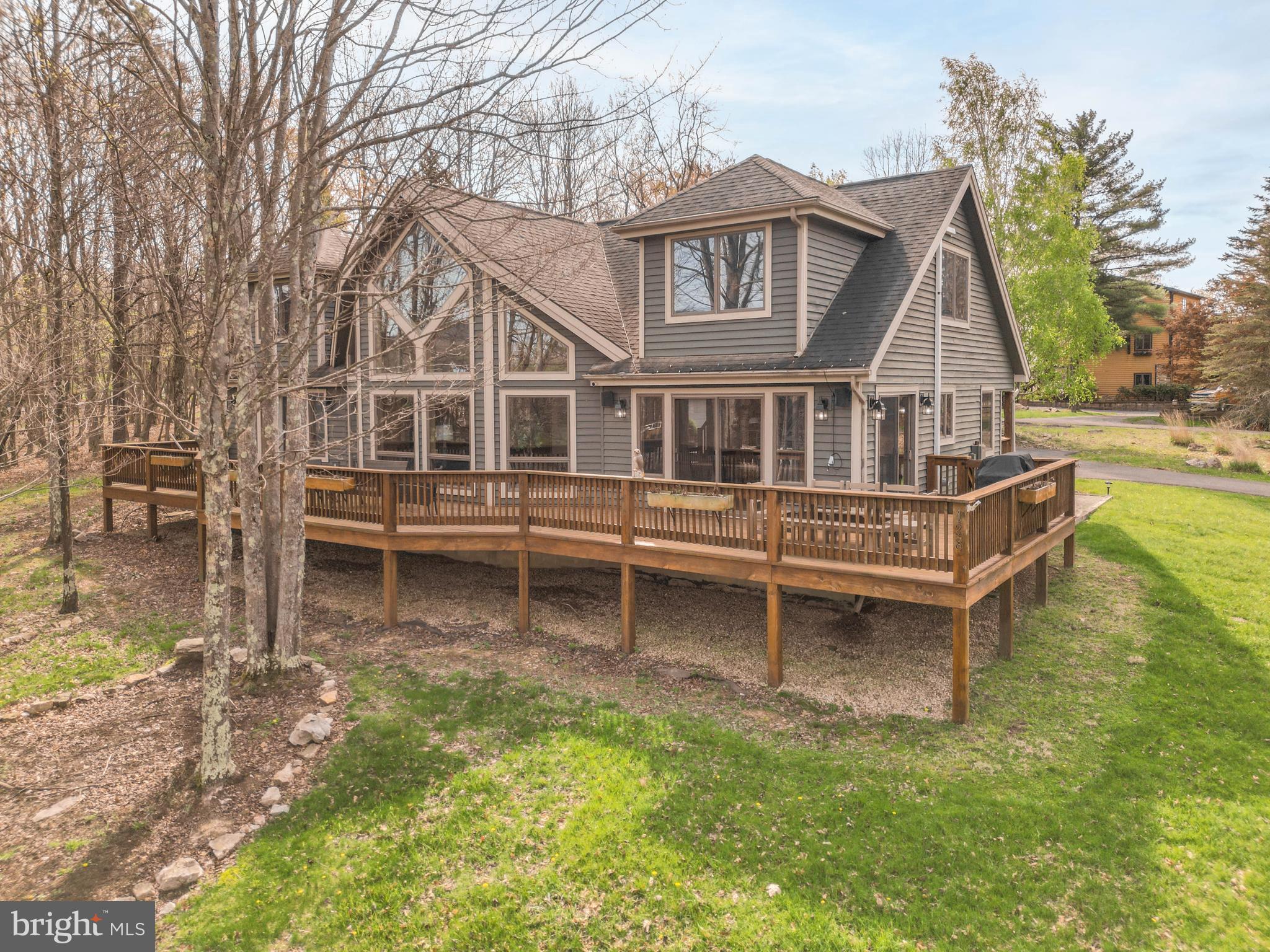 128 Bridgeview Lane Swanton, MD 21561 - Photo 52 of 70 a white house that has a small yard and a wooden bench in it