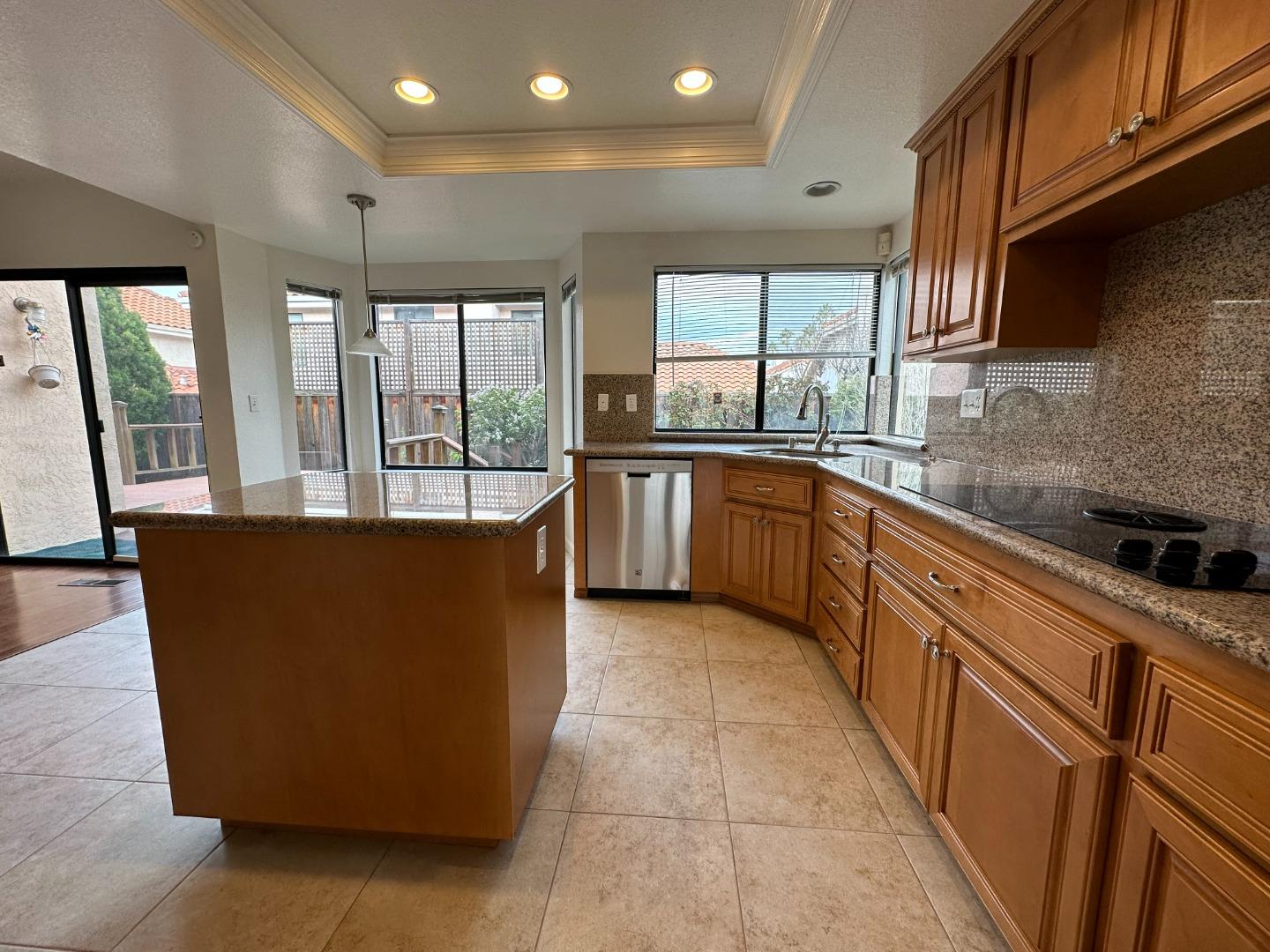 645 Kirby Common Fremont, CA 94539 - Photo 11 of 39 a large kitchen with stainless steel appliances granite countertop a refrigerator a sink dishwasher a dining table and chairs with wooden floor