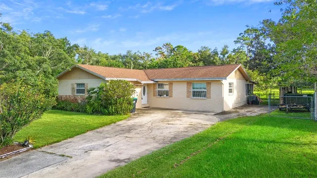 a view of a house with a yard and potted plants