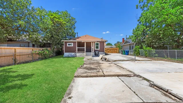 a front view of a house with a garden and trees