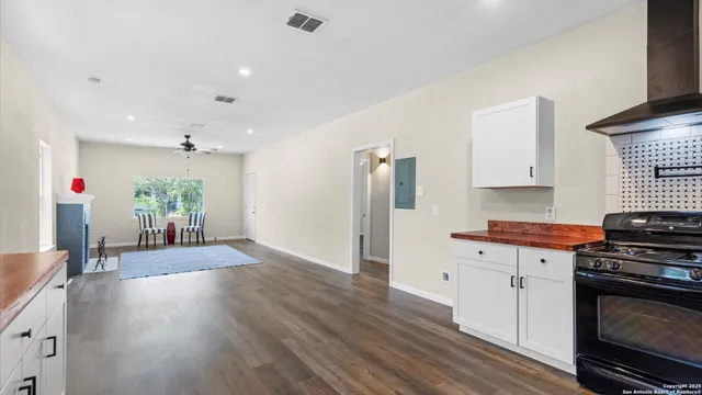 a kitchen with granite countertop a stove and a wooden floor