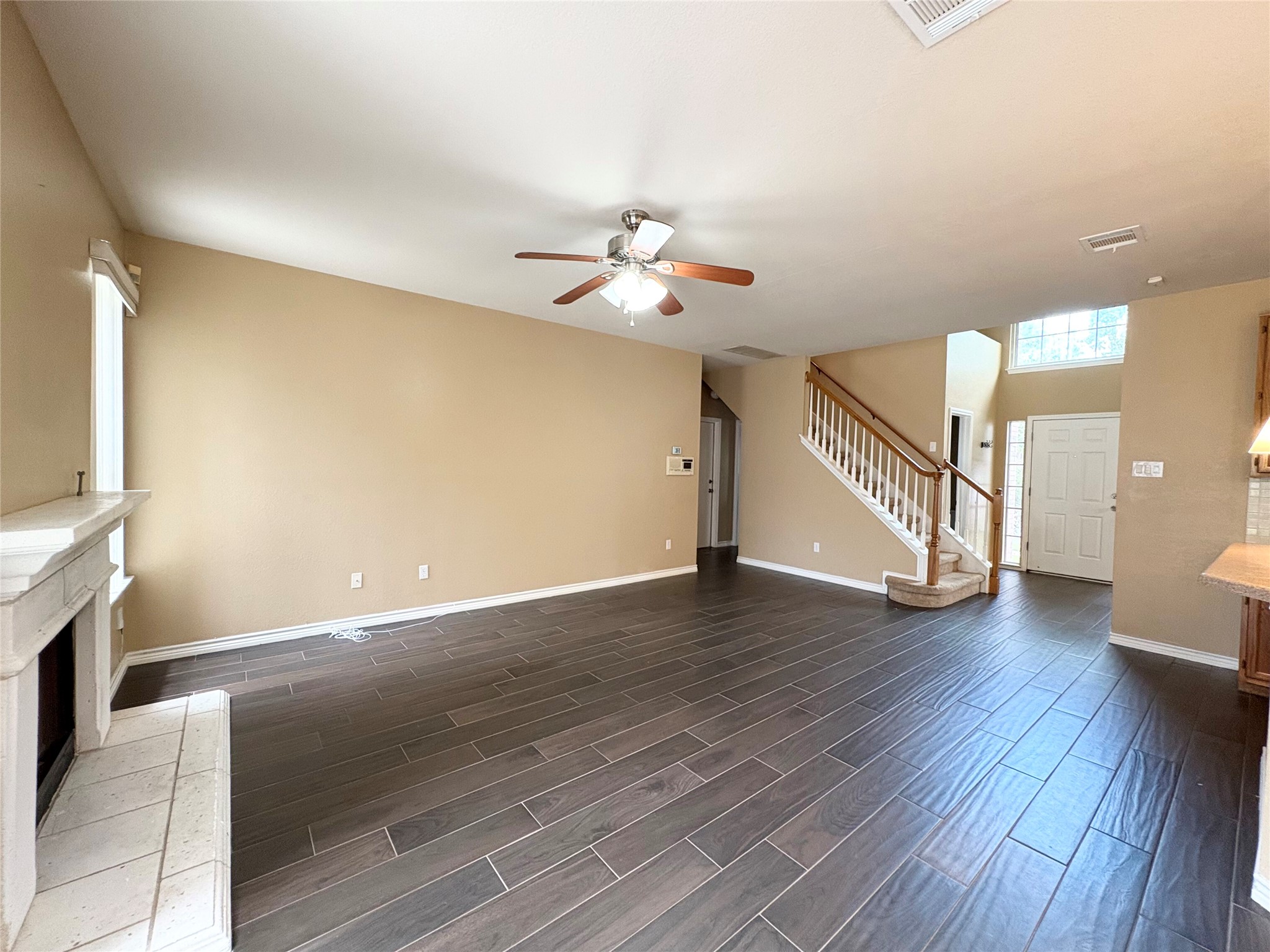 8103 Ephraim Road Austin, TX 78717 - Photo 7 of 35 A spacious living area with warm walls and rich dark tile flooring flows into a grand entry with a prominent staircase.