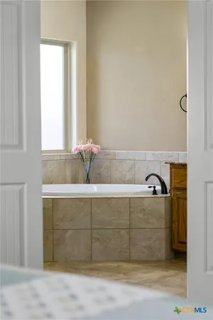 a bathroom with a double vanity sink mirror and bathtub