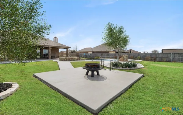 a view of a patio with table and chairs potted plants and a big yard