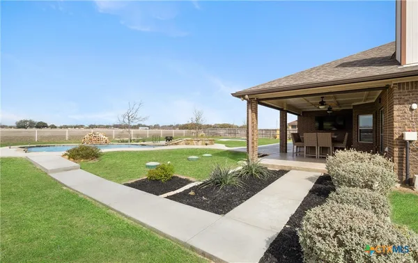 a view of a house with swimming pool and a yard
