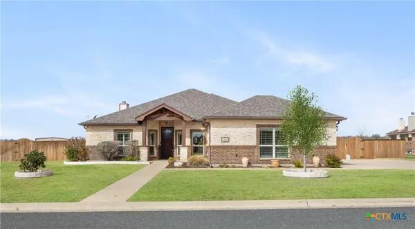 a front view of a house with a garden and yard
