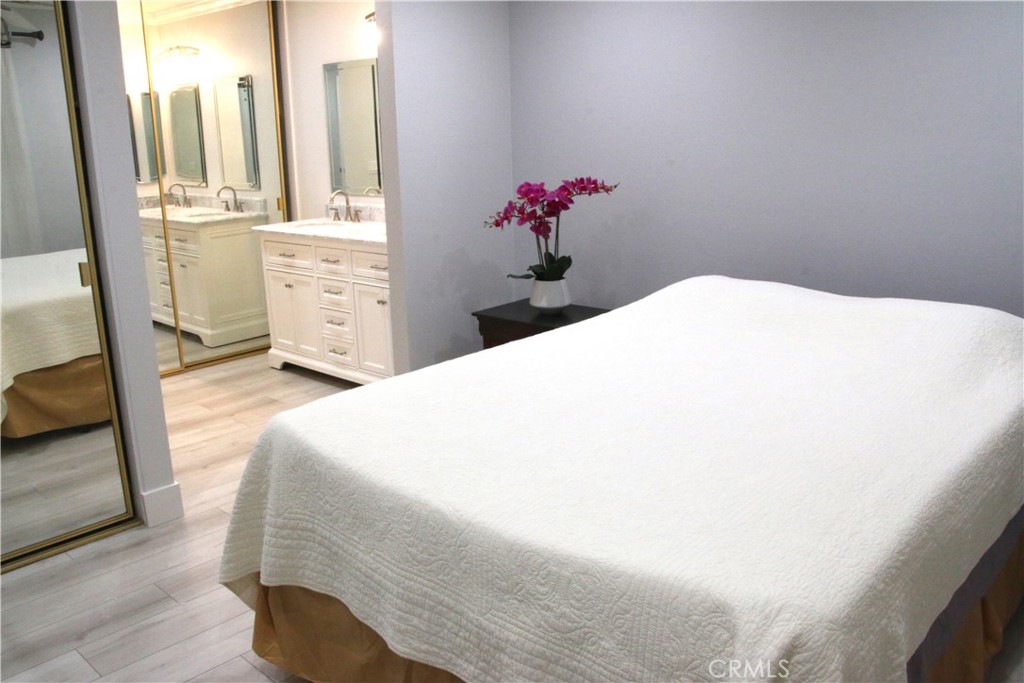 7735 Moordale Circle, Unit 246 Stanton, CA 90680 - Photo 11 of 21 a bedroom with a bed and a chandelier