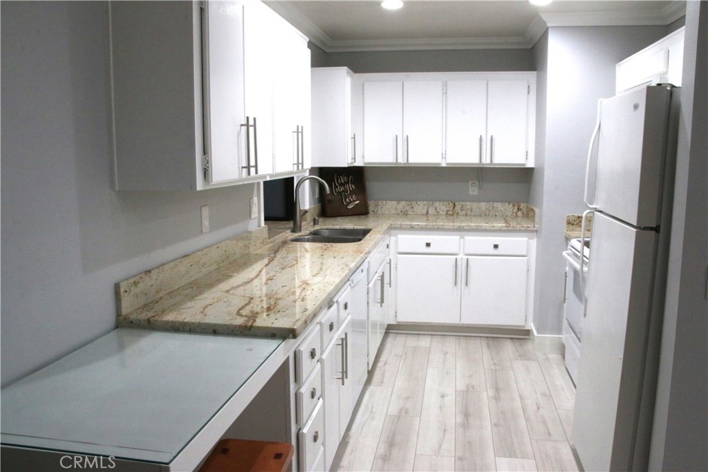 7735 Moordale Circle, Unit 246 Stanton, CA 90680 - Photo 17 of 21 a kitchen with a stove a refrigerator and a sink