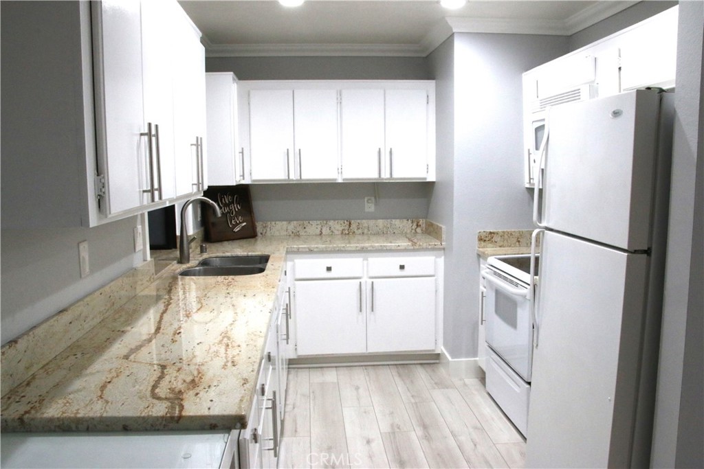 7735 Moordale Circle, Unit 246 Stanton, CA 90680 - Photo 2 of 21 a kitchen with a refrigerator sink and cabinets
