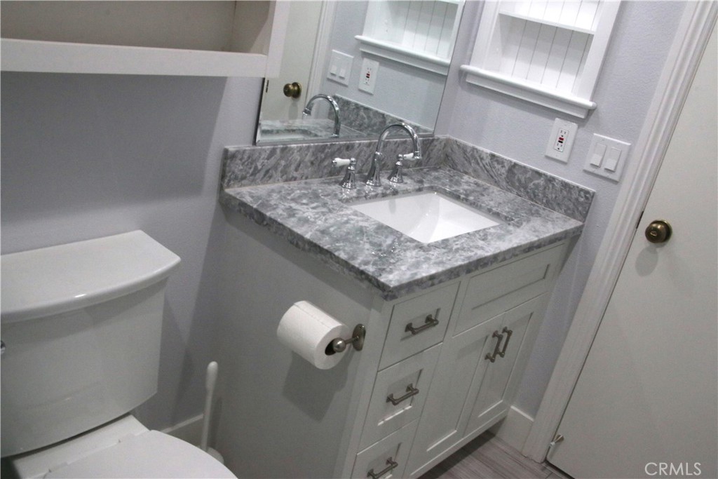 7735 Moordale Circle, Unit 246 Stanton, CA 90680 - Photo 7 of 21 a bathroom with a granite countertop sink and a mirror