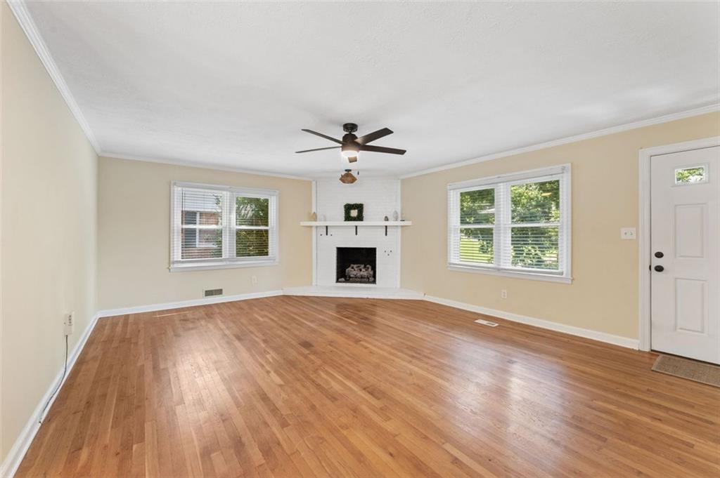 729 Timberland Street Smyrna, GA 30080 - Photo 6 of 26 an empty room with wooden floor ceiling fan and windows