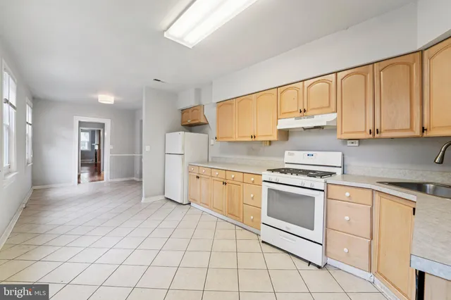 a kitchen with white cabinets appliances and a window
