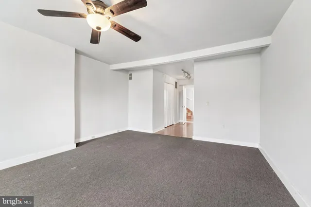 an empty room with chandelier fan