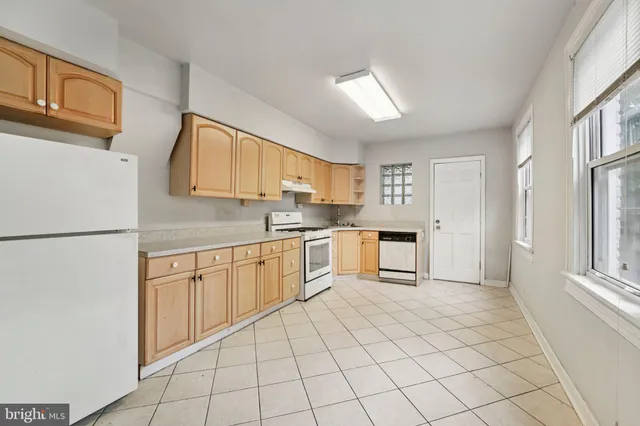 a kitchen with granite countertop cabinets stainless steel appliances a sink and a window