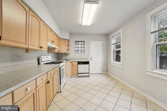a kitchen with granite countertop white cabinets and window