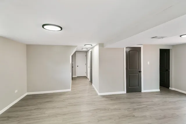 a view of an empty room with wooden floor and closet