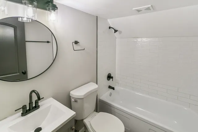 a bathroom with a sink a mirror toilet and bathtub