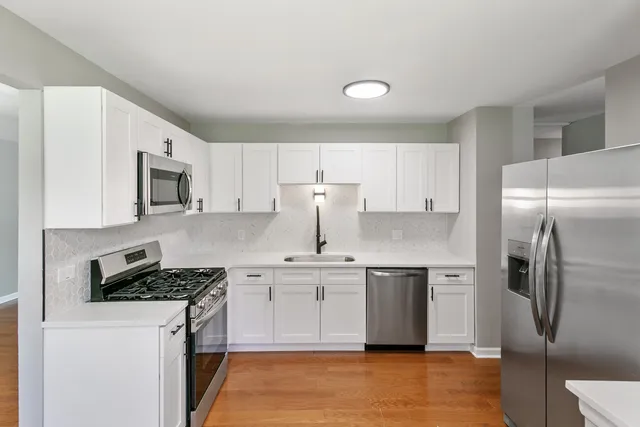 a kitchen with stainless steel appliances a refrigerator sink and microwave