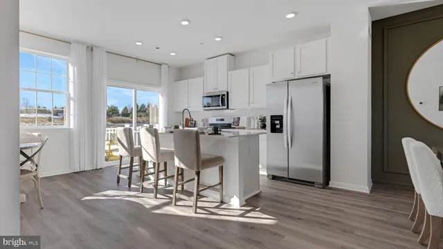 a kitchen with kitchen island stainless steel appliances a refrigerator and a dining table