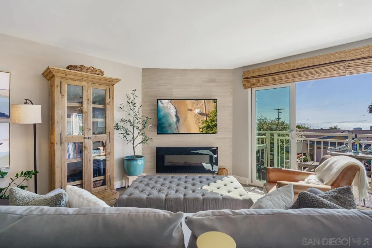 5366 La Jolla Boulevard, Unit 101C La Jolla, CA 92037 - Photo 25 of 41 a living room with furniture a fireplace and a floor to ceiling window