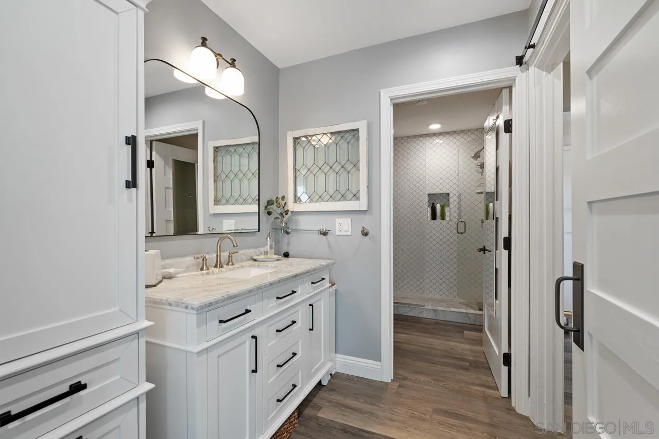 5366 La Jolla Boulevard, Unit 101C La Jolla, CA 92037 - Photo 33 of 41 a bathroom with a double vanity sink mirror and shower