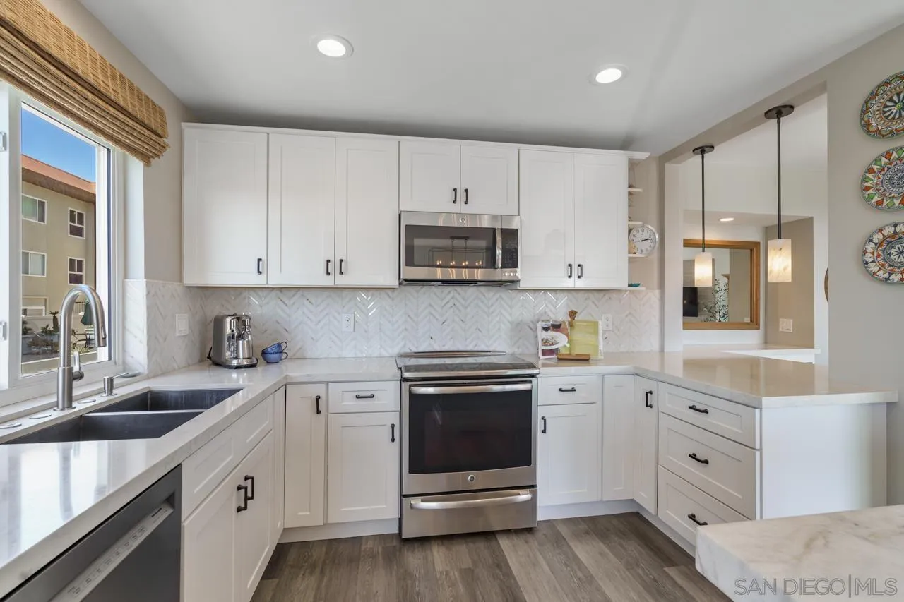 5366 La Jolla Boulevard, Unit 101C La Jolla, CA 92037 - Photo 6 of 41 a kitchen with white cabinets white stainless steel appliances and sink