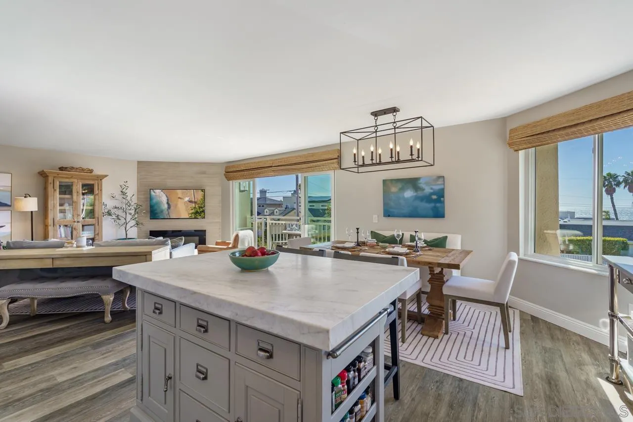 5366 La Jolla Boulevard, Unit 101C La Jolla, CA 92037 - Photo 9 of 41 a kitchen with a stove a refrigerator and a dining table with wooden floor