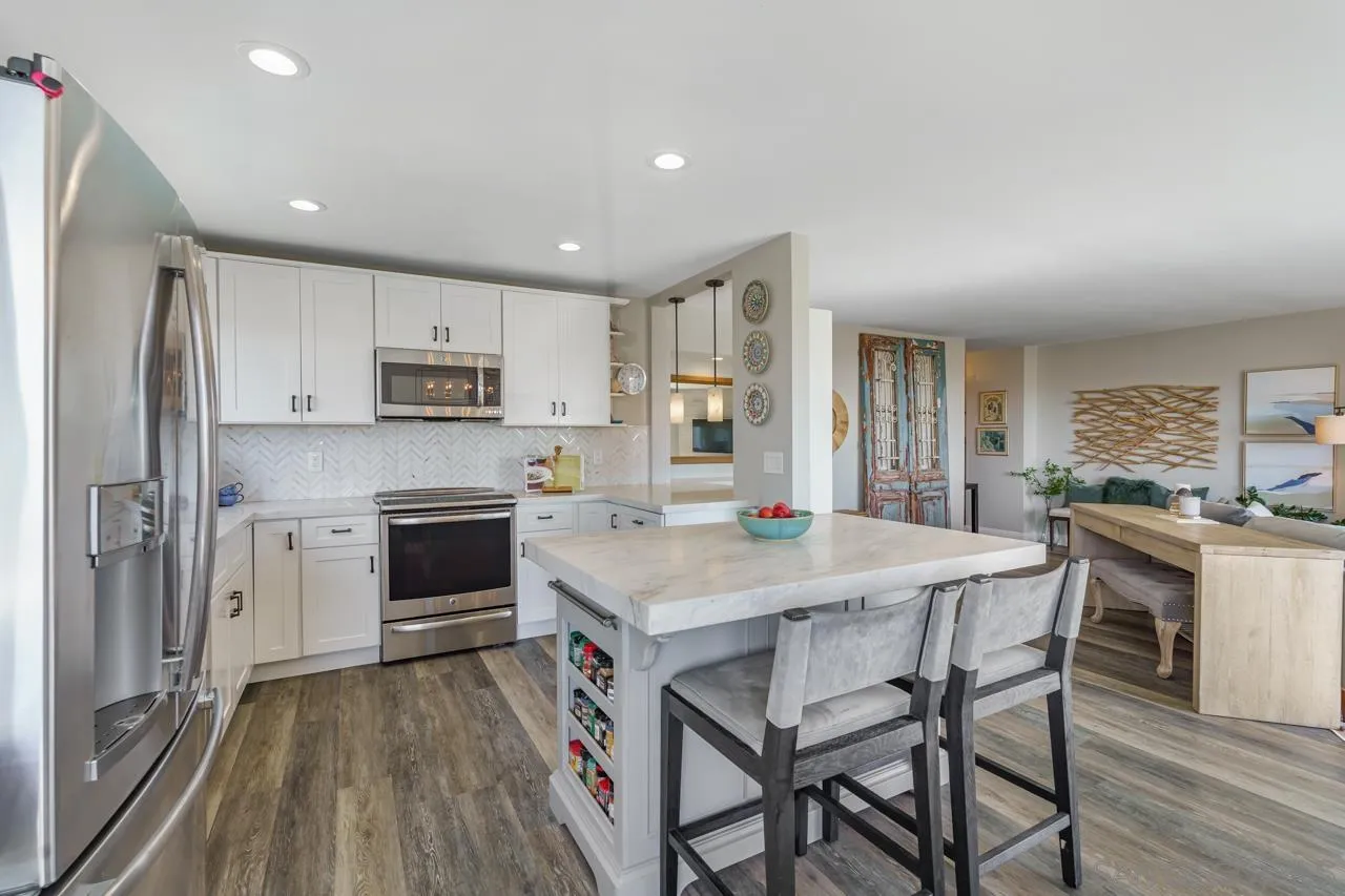 5366 La Jolla Boulevard, Unit 101C La Jolla, CA 92037 - Photo 10 of 41 a kitchen with kitchen island a white counter top space a stove a refrigerator cabinets and a center island