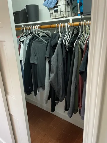 a view of walk in closet with clothes and shoes