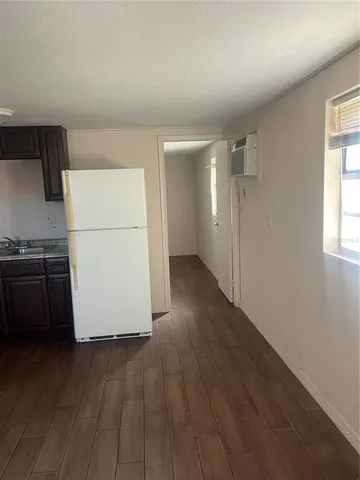 a view of a kitchen with wooden floor and electronic appliances