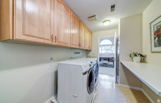 1273 Grayson Court Sandy, UT 84094 - Photo 20 of 27 Utility room featuring extensive upper cabinetry, a built-in folding counter, and tile flooring