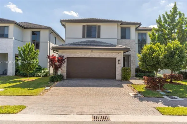 a view of a house with a yard and potted plants