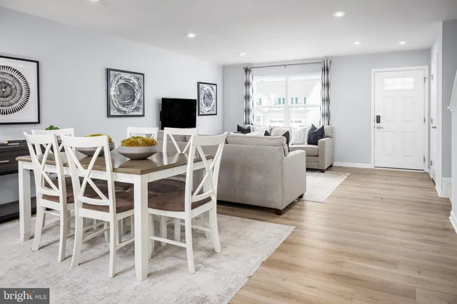 a living room with furniture a flat screen tv and a large window