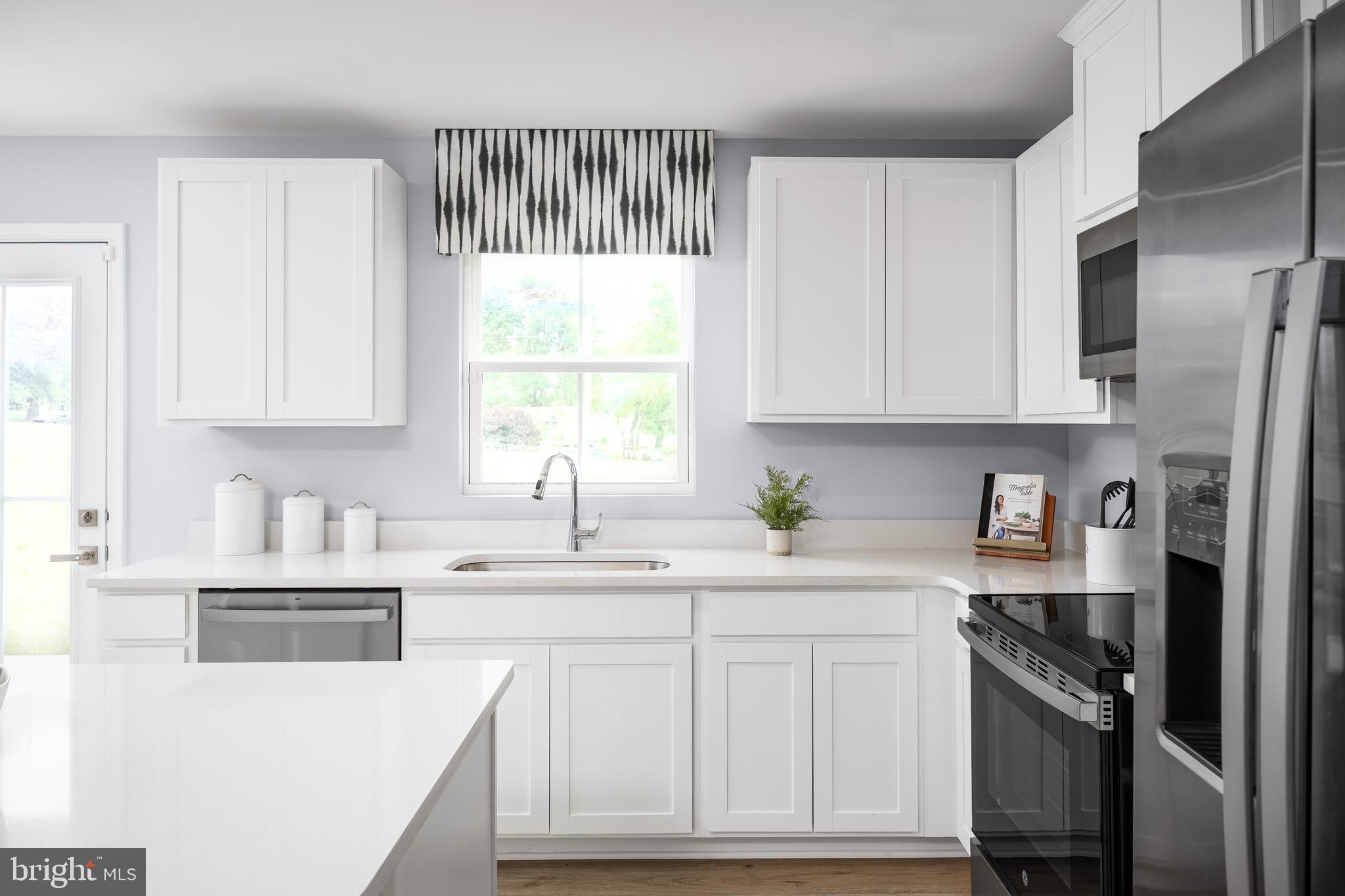 2204 Mutual Drive Inwood, WV 25428 - Photo 8 of 20 a kitchen with stainless steel appliances granite countertop a sink a stove a refrigerator and cabinets