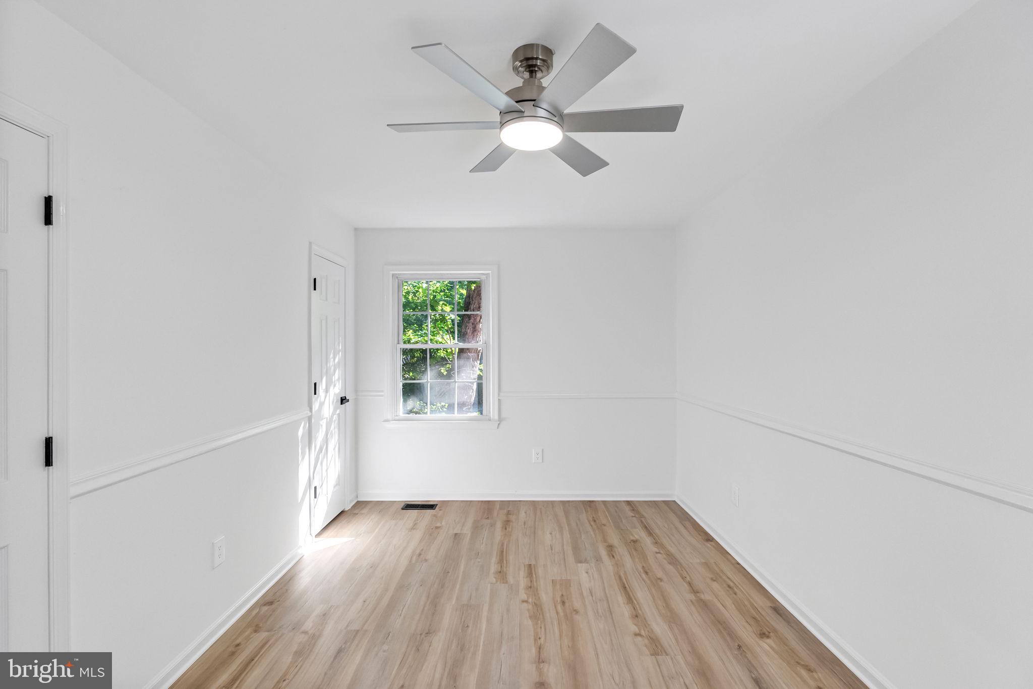 3 Boston Cove Ruther Glen, VA 22546 - Photo 23 of 30 an empty room with wooden floor chandelier fan and windows